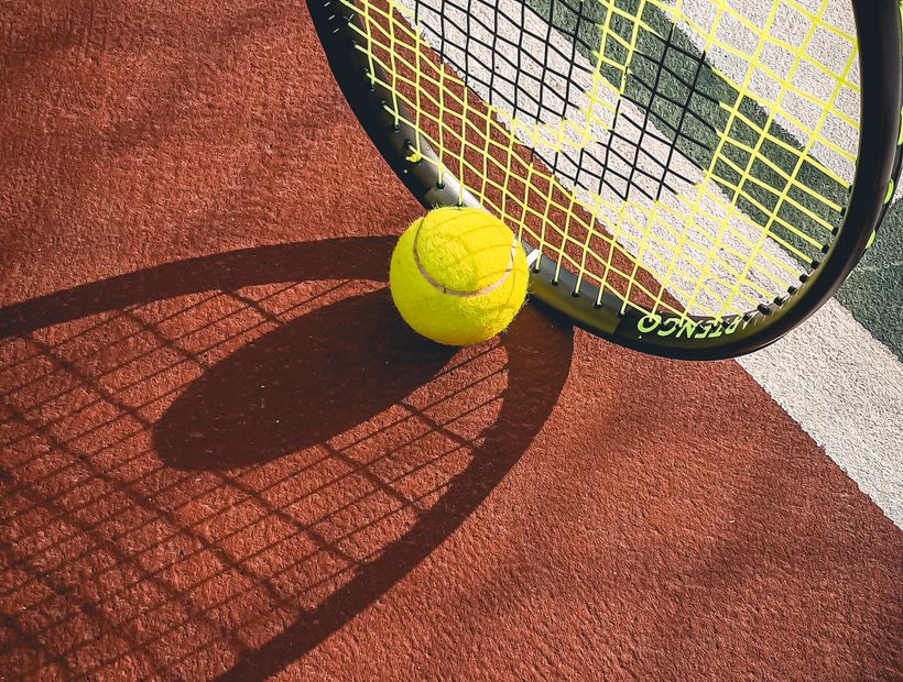 A tennis racquet and ball on court